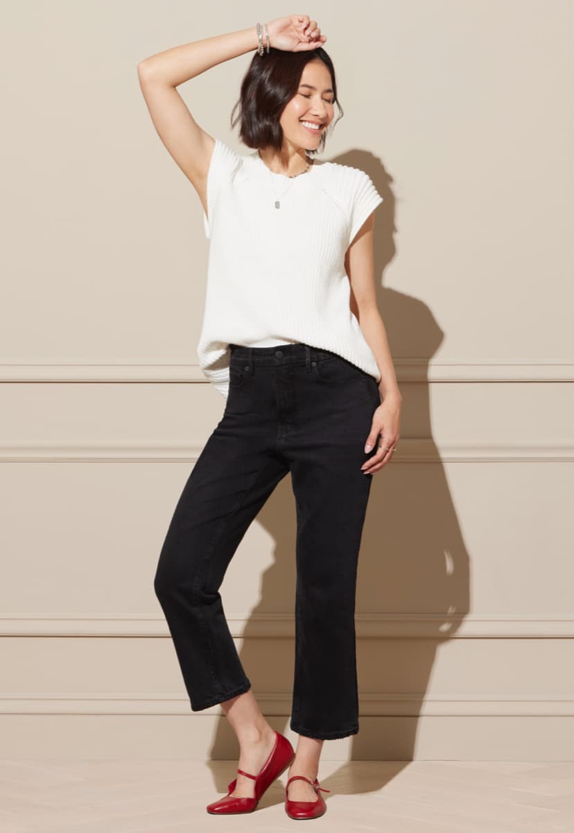 Woman wearing black cropped jeans with a white tee and red mary jane flats. 