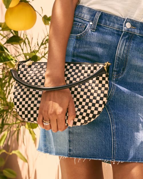 Image of woman holding a black and white check leather handbag