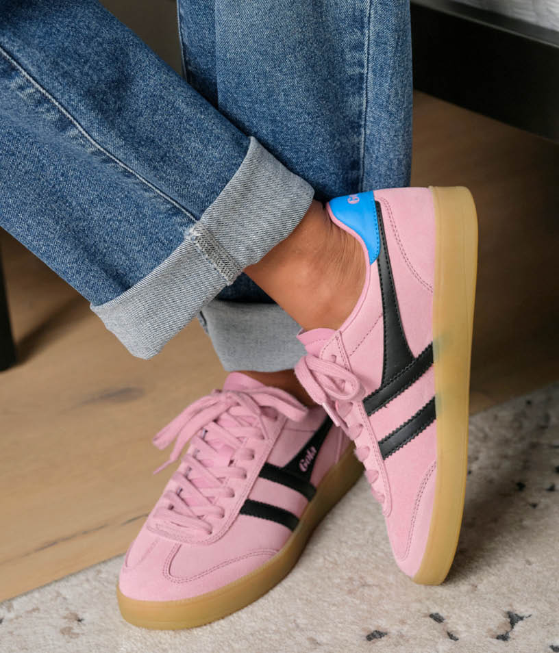 Image of woman wearing blue jeans and pink Gola sneakers.