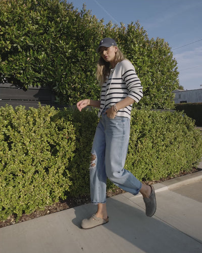 Video of woman wearing stripe sweater and blue jeans. 